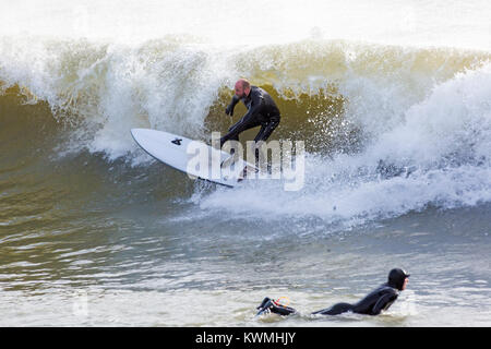 Bournemouth, Dorset, England UK. 4th January, 2018. UK weather:  surfer riding a wave enjoying the surf on a windy day at Bournemouth beach, as the surfers make the most of the windy conditions and big waves. Credit: Carolyn Jenkins/Alamy Live News Stock Photo