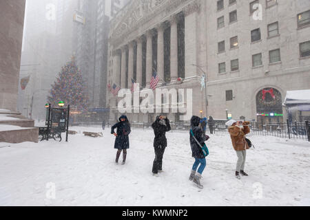 New York, USA. 04th Jan, 2018. Tourists and workers trudge through the snow in Lower Manhattan in front of the New York Stock Exchange during the first nasty winter storm of the new year on Thursday, January 4, 2018. Mother Nature is predicted to dump 5 to 8 inches of snow in the city and to make matters worse, is adding gusty winds into the mix. The snow will be followed by single digit temperatures guaranteeing that the mounds of the white stuff will never melt. ( © Richard B. Levine) Credit: Richard Levine/Alamy Live News Stock Photo