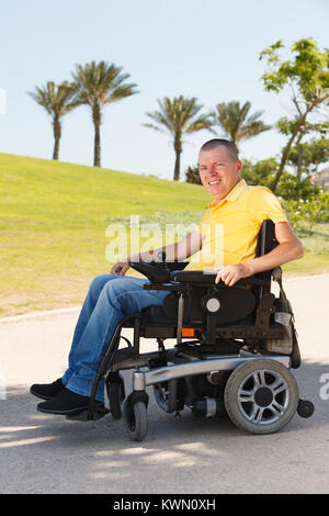 Disabled man sitting in wheelchair at the park Stock Photo