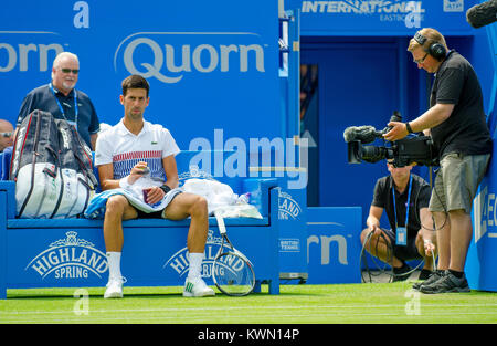 Novak Djokovic (Serbia) being filmed by a TV cameraman on centre court at Devonshire Park, Eastbourne, during the Aegon International tournament, 30th Stock Photo