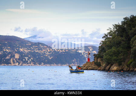 Small fishing boat at the entrance in the bay at Portofino, Liguria, Italy Stock Photo