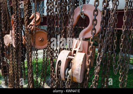 Old rusty metal hoist chain and pulley- Several old industrial chain and pulley Stock Photo