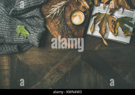 Autumn morning coffee concept with leaves, jamper and book Stock Photo