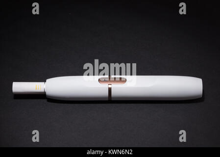 Newest electronic cigarettes, heating tobacco system IQOS, smoking, white isolated on black background Stock Photo