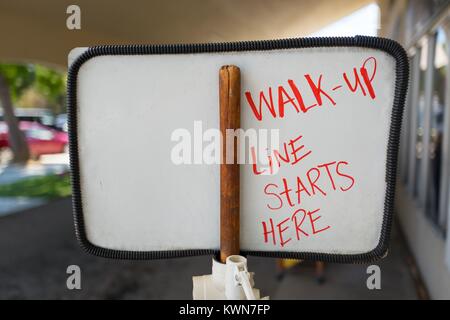 Improvised sign constructed with a broom handle, with hand-drawn lettering reading 'Walk-up Line Starts Here' at Meadowlark Dairy, a classic drive-up dairy bar, originally opened in 1969, with signage reading 'Milk', in downtown Pleasanton, California, July 18, 2017. Stock Photo