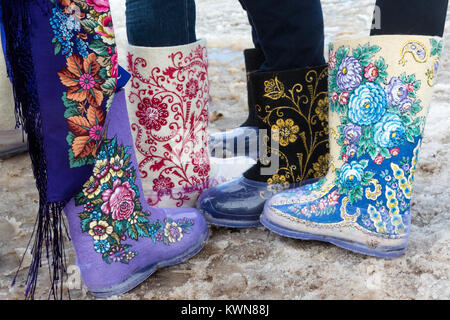 Youth walks in felt boots with embroidery on a rustic holiday in winter Stock Photo