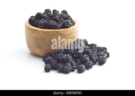 Dried chokeberries. Black aronia berries in bowl. Isolated on white background.