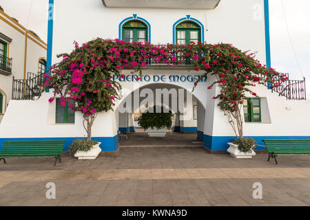 Puerto de Mogan, Gran Canaria in Spain - December 16, 2017: Puerto de Mogan, pink and red flowers growing over the arch at the ferry pier Stock Photo