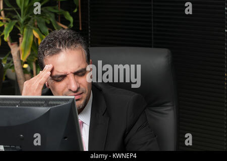 Business man suffering from a headache at work Stock Photo