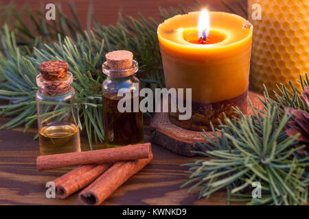 Essential oils, cinnamon stick and handmade burning beewax candle with cinnamon and essential oil Stock Photo