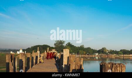 U-BEIN BRIDGE, AMARAPURA, MYANMAR SEPTEMBER 21: Buddhist monks on their daily walk across the bridge in the early morning hours September 21, 2017,U B Stock Photo