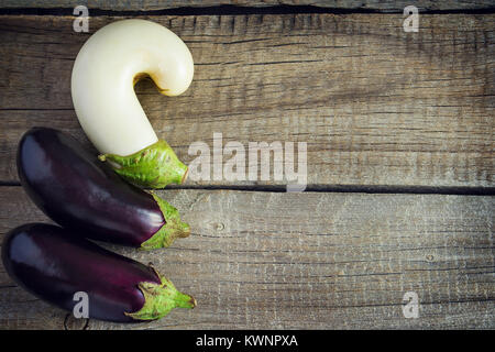 Three eggplants on an old wooden table, Copy space background. Stock Photo