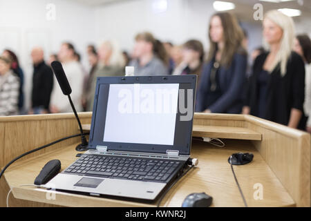 Laptop and microphone on the rostrum in lecture hall full of conference participants. Stock Photo