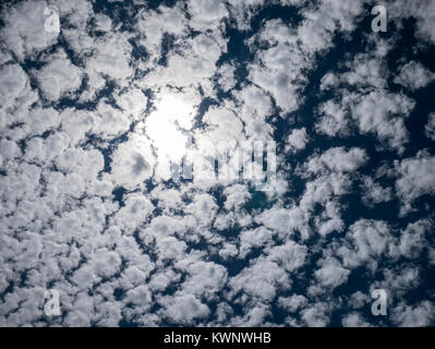 Backlit puffy clouds & sun against cobalt blue sky; Aeroparque Jorge Newbery; Buenos Aires; Argentina Stock Photo