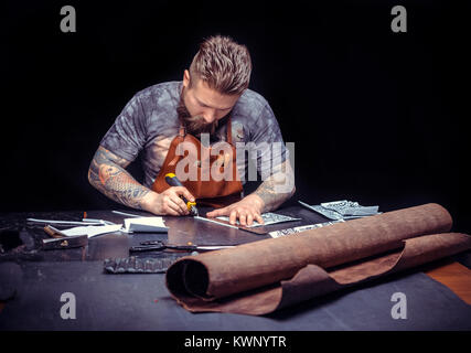 Leather cutter being keen on his buisness in the workplace Stock Photo