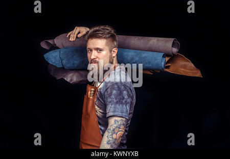 Leather man cutting out leather goods at the desk Stock Photo