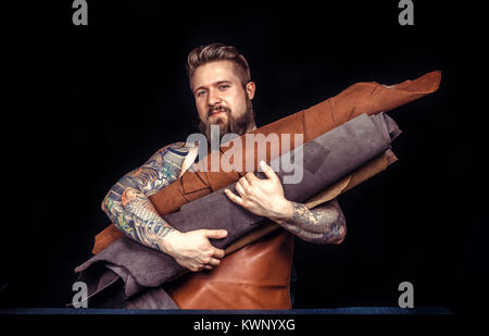 Leather master cuts out leather goods Stock Photo