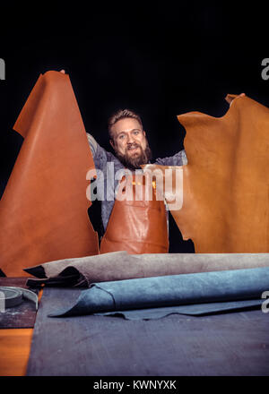 Professional Leather Worker cutting out leather goods at the tanner shop Stock Photo