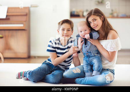 Portrait of young pretty teenage girl with her baby brother and 9 years old brother Stock Photo