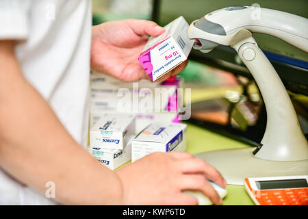 Pharmacist scanning barcode of medicine drug in a pharmacy drugstore. Stock Photo