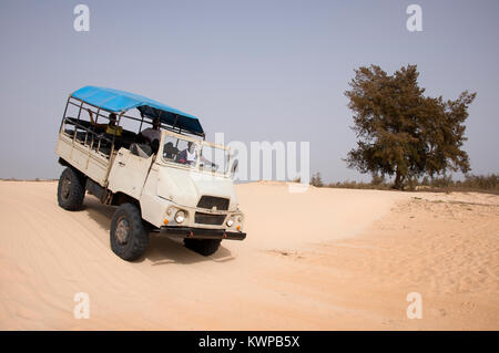All-terrain truck driving through the dunes, on the coast of Pink Lake in Senegal Stock Photo