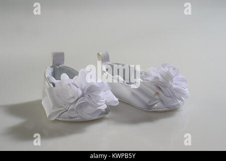 White cute baby's first shoes on white background. Stock Photo