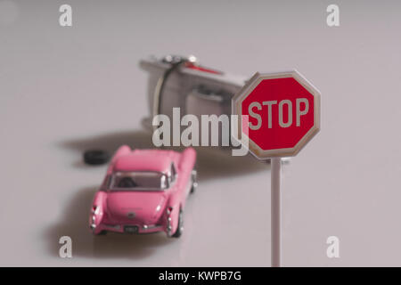 Two retro toy cars in an accident under a stop sign. Stock Photo