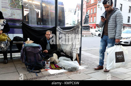 Stuart (no surname given) with his possessions in a bus stop near Windsor Castle, Berkshire. Prime Minister Theresa May has said she disagrees with Tory council leader Simon Dudley, who called on police to clear rough sleepers from Windsor before the royal wedding. Stock Photo