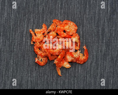 Dried shrimp or prawn isolated on dark linen background used as ingredient in Thai green papaya salad Stock Photo