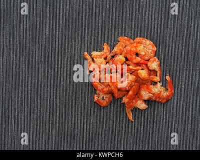 Dried shrimp or prawn isolated on dark linen background used as ingredient in Thai green papaya salad Stock Photo