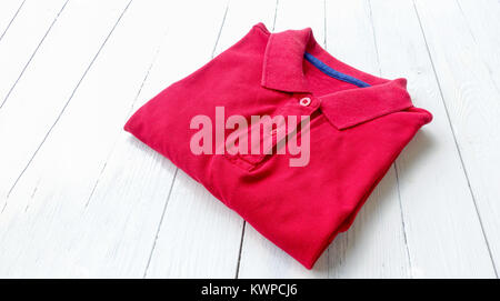 red polo shirt put on white wooden table Stock Photo