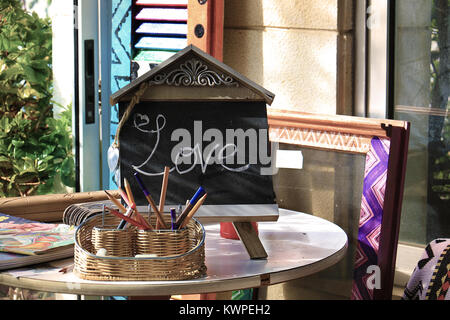 The word love written in chalk on a blackboard in a colorful setting. Stock Photo