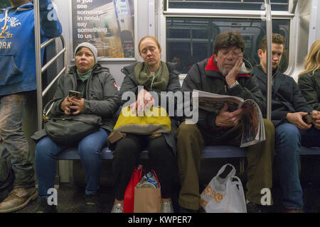 People ride home from work on a New York City subway train during the evening rush hour. Stock Photo