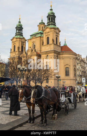 PRAGUE, CZECH REPUBLIC - DEC 23RD 2017: A view of St. Nicholas Church with horse and carriage in the foreground, in the historic Old Town Square in Pr Stock Photo