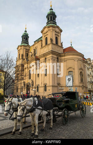 PRAGUE, CZECH REPUBLIC - DEC 23RD 2017: A view of St. Nicholas Church with horse and carriage in the foreground, in the historic Old Town Square in Pr Stock Photo