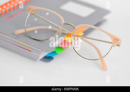 Eye glasses with spiral notebook on white background Stock Photo