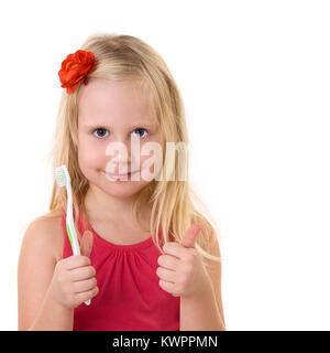 Child with a toothbrush shows thumbs up Stock Photo