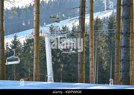 WINTERBERG, GERMANY - FEBRUARY 15, 2017: Chairlift going through a pine tree forest at Ski Carousel Winterberg Stock Photo