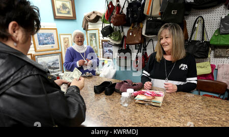 Davenport, Iowa, USA. 10th Jan, 2017. Customer Susan Peavy of Davenport pays for her purchase with the help of volunteer Rhonda Johnson of Moline, Tuesday, January 10, 2017, at Winnie's Wishes resale shop in Davenport. In the background is volunteer Marilyn Burns of Andover, IL. Credit: John Schultz/Quad-City Times/ZUMA Wire/Alamy Live News Stock Photo