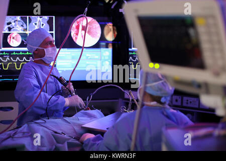 Professor Gero Strauss (L) performs a paranasal sinus surgery with the help of an operation software in an operating room in his clinic in Leipzig, Germany, 30 November 2017. With his co-worker the (Surgical Procedure Manager): A navigation system for an operation. For different operations the sofware plays the respective process step by step, a computerised voice announces the status of the operation. With this device operations are performed more standardised and in some cases even much faster as the surgical nurses know exactly which instrument will be needed next. Photo: Jan Woitas/dpa-Zen Stock Photo