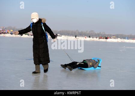 Harbin, China's Heilongjiang Province. 5th Jan, 2018. A mum and her child play on ice in Harbin, capital of northeast China's Heilongjiang Province, Jan. 5, 2018. Credit: Wang Kai/Xinhua/Alamy Live News Stock Photo