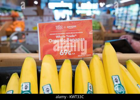 Signage on a display of bananas at the Whole Foods Market store in San Ramon, California reading 'Whole Foods Market and Amazon, New Lower Price, More to Come', announcing Whole Foods Market's lowering of prices on many fresh items following its acquisition by online retailer Amazon, August 28, 2017. On August 28, 2017, Amazon completed its acquisition of the upscale grocery chain. Stock Photo