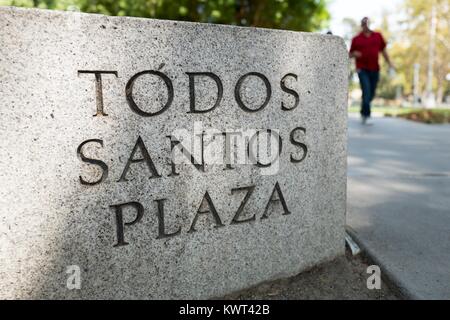 Signage for Todos Santos Plaza, a public park which is the focal point of downtown Concord, California, with two people walking through the plaza visible, with selective focus, in the background, September 8, 2017. Stock Photo