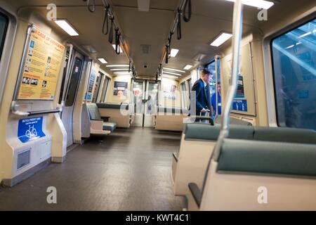 A man in a business suit exits a Bay Area Rapid Transit (BART) light rail train at San Francisco International Airport, San Francisco, California, September 13, 2017. Stock Photo