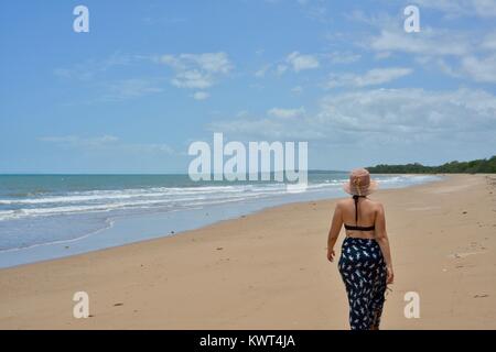 Women walking alone on a remote tropical beach, Balgal Beach, Queensland, Australia Stock Photo