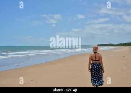 Women walking alone on a remote tropical beach, Balgal Beach, Queensland, Australia Stock Photo