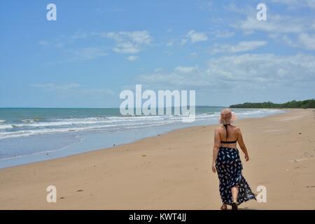 Women walking alone on a remote tropical beach, Balgal Beach, Queensland, Australia Stock Photo