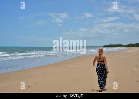 Women walking alone on a remote tropical beach, Balgal Beach, Queensland, Australia Stock Photo