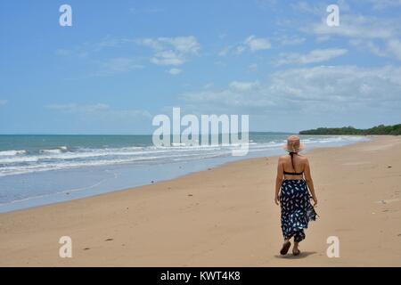 Women walking alone on a remote tropical beach, Balgal Beach, Queensland, Australia Stock Photo