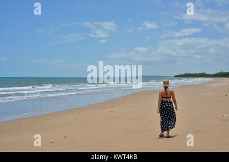 Women walking alone on a remote tropical beach, Balgal Beach, Queensland, Australia Stock Photo